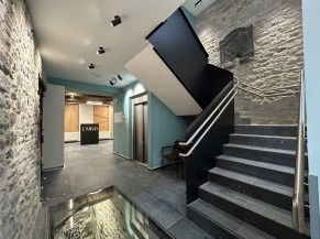 Ground floor : staircase, lift and reception at the back. Glass floor (view of cellar stairs)