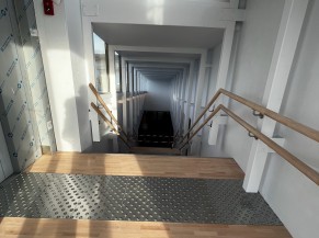 Accès direct à l'accueil via un ascenseur ou en empruntant cet escalier équipé de deux doubles mains courantes et de dalles d'éveil à la vigilance