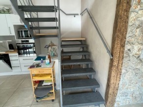 Escaliers contrastés, avec main courante de part et d'autre qui mène à l'étage