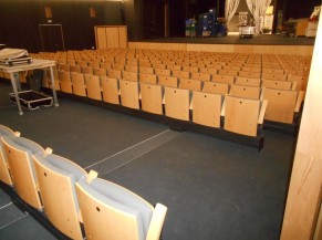 Intérieur de la grande salle avec les sièges mobiles pour dégager des places pour PMR
