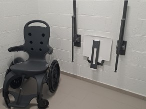 Cabine adaptée avec siège et barres d'appui, sèche-cheveux et fauteuil roulant de piscine