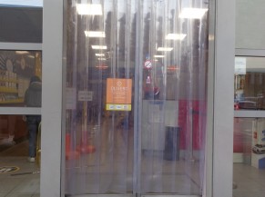 Porte d'entrée coulissante automatique avec rideau en larges lanières PVC souples