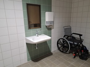 Cabine adaptée : lavabo et fauteuil roulant de piscine