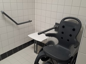 partie du vestiaire collectif adapté, avec siège rabattable et mise à disposition du fauteuil roulant de piscine